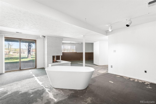 12940 W 75th Ave, Arvada, CO 80005 - bathroom with a brick fireplace, a freestanding tub, and a textured ceiling