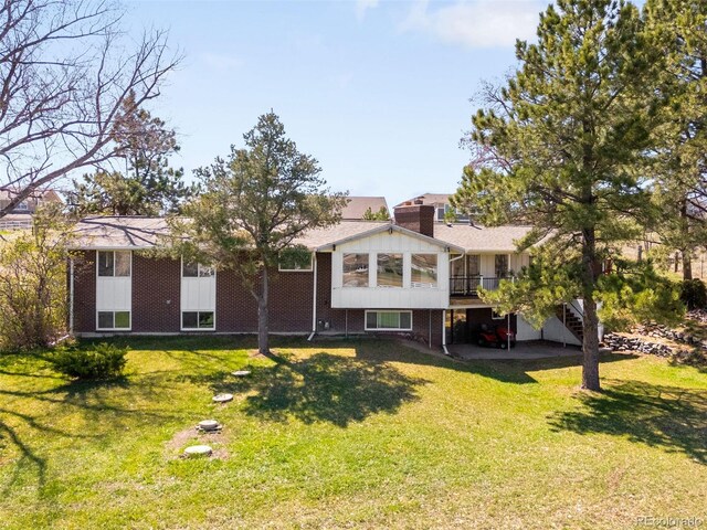 12940 W 75th Ave, Arvada, CO 80005 - view of front of property with stairway, a deck, a front lawn, and brick siding