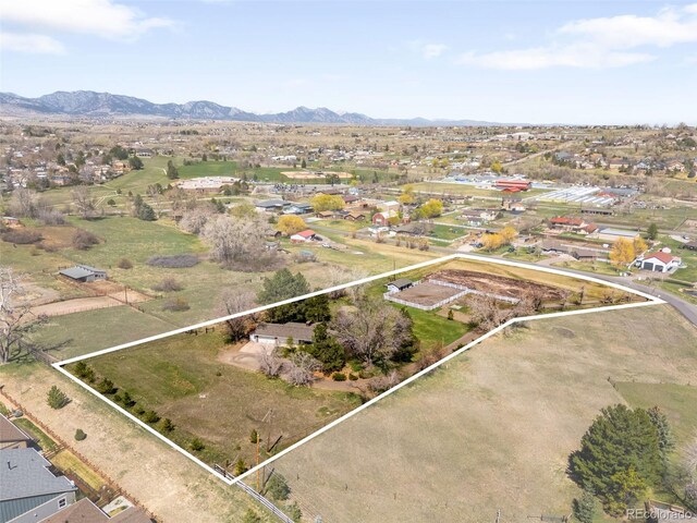 12940 W 75th Ave, Arvada, CO 80005 - aerial view of property's location featuring property parcel outlined, a mountain backdrop, and nearby suburban area