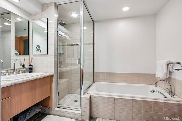 1401 Wewatta St Unit 911, Denver, CO 80202 - bathroom with a garden tub, vanity, a stall shower, recessed lighting, and tasteful backsplash