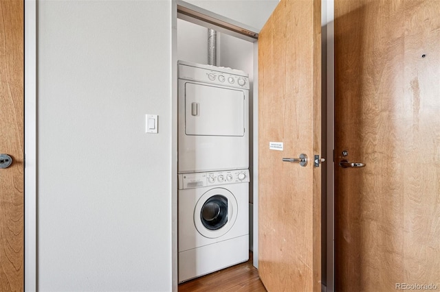 1401 Wewatta St Unit 911, Denver, CO 80202 - washroom featuring stacked washing machine and dryer and wood finished floors