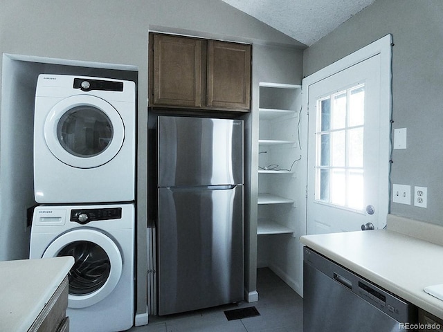 9669 W Chatfield Ave Unit A, Littleton, CO 80128 - laundry room with stacked washer / dryer, light tile patterned flooring, and a textured ceiling