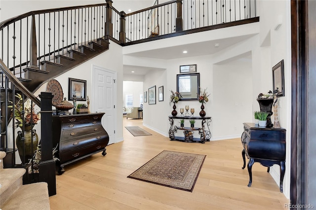 entryway featuring a high ceiling and light hardwood / wood-style flooring