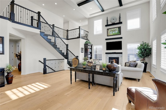 living room with beam ceiling and light wood-type flooring