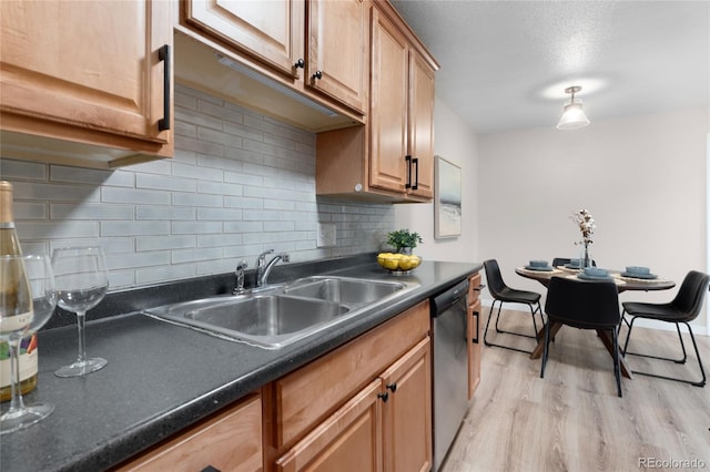 16359 W 10th Ave Unit T1, Golden, CO 80401 - kitchen with dishwasher, dark countertops, a sink, backsplash, and light wood finished floors