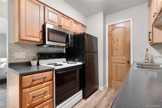 16359 W 10th Ave Unit T1, Golden, CO 80401 - kitchen featuring stainless steel microwave, range with electric stovetop, a sink, light wood-style flooring, and dark countertops