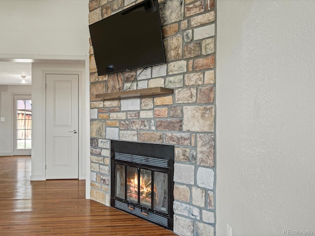 room details with baseboards, wood finished floors, and a fireplace
