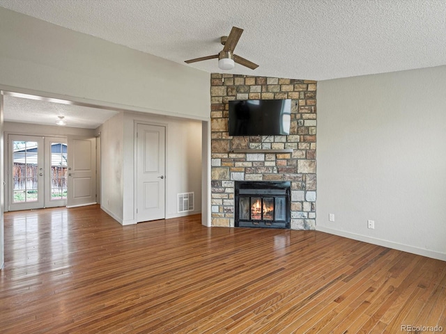 unfurnished living room with a ceiling fan, a textured ceiling, and wood finished floors