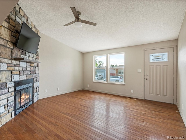 unfurnished living room with a ceiling fan, a textured ceiling, plenty of natural light, and hardwood / wood-style floors