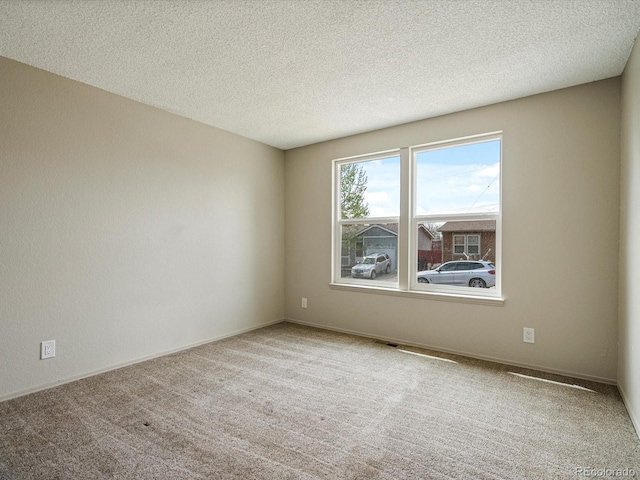 carpeted spare room with a textured ceiling