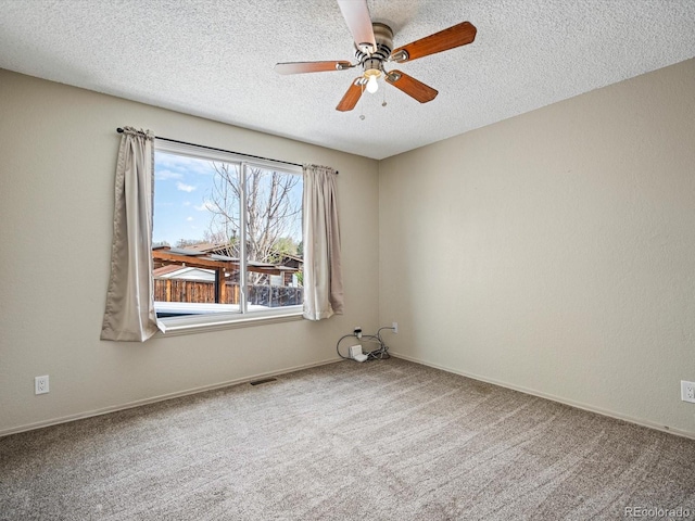 unfurnished room with ceiling fan, carpet, a textured ceiling, and visible vents