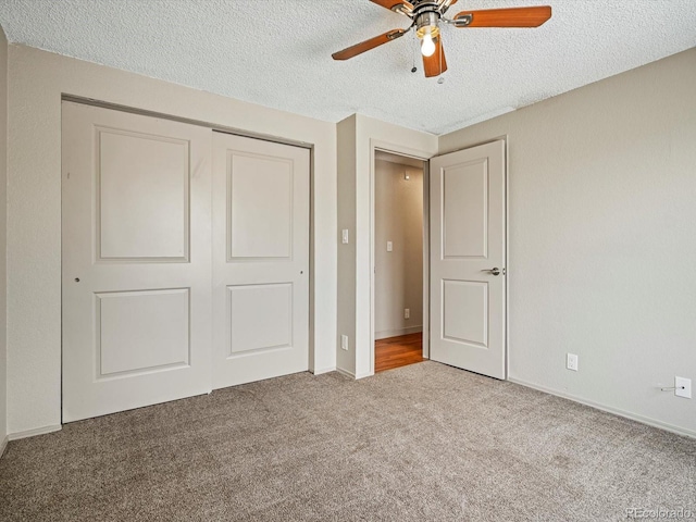 unfurnished bedroom featuring a closet, carpet flooring, a textured ceiling, and ceiling fan