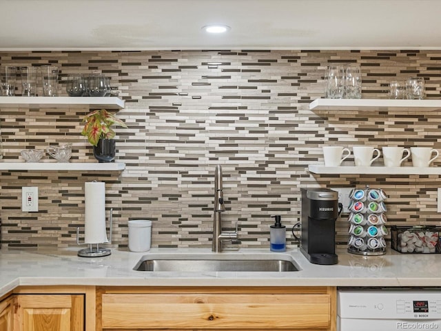 kitchen featuring a sink, light countertops, tasteful backsplash, and white dishwasher