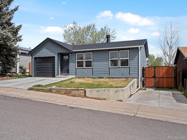 ranch-style home featuring roof with shingles, fence, a garage, a gate, and concrete driveway