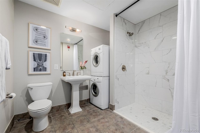 bathroom featuring a shower with curtain, sink, toilet, and stacked washer and clothes dryer