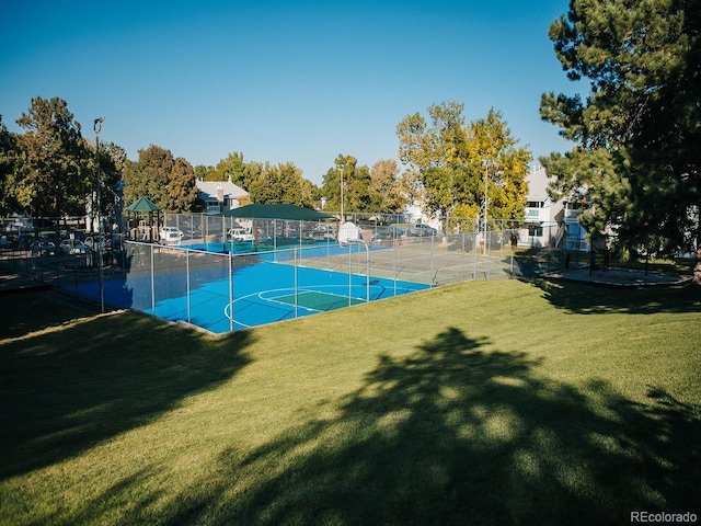 view of sport court featuring tennis court and a yard