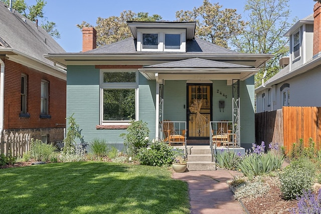 2445 N Franklin St, Denver, CO 80205 - view of front facade with a porch, a chimney, and roof with shingles
