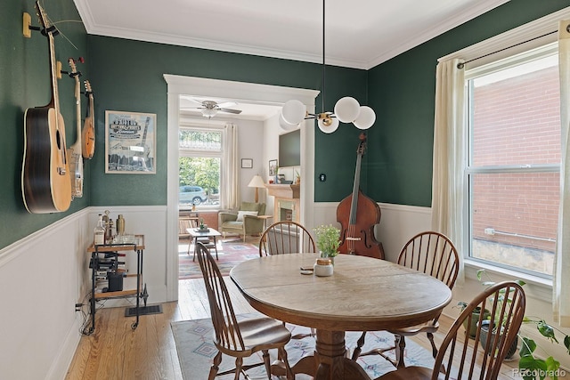 2445 N Franklin St, Denver, CO 80205 - dining space featuring wainscoting, light wood finished floors, crown molding, and a ceiling fan