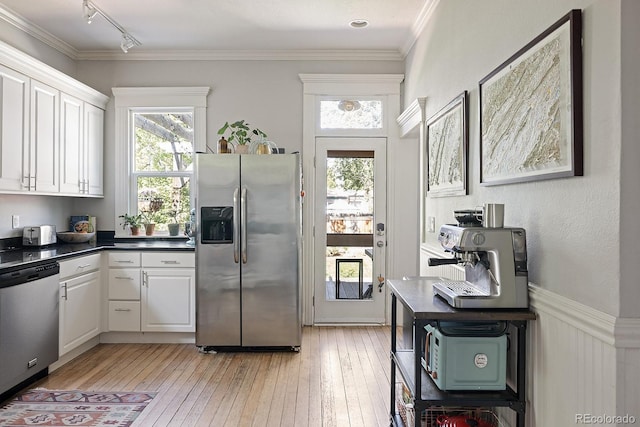 2445 N Franklin St, Denver, CO 80205 - kitchen with appliances with stainless steel finishes, white cabinetry, light wood-type flooring, rail lighting, and crown molding