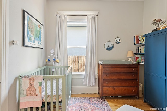 2445 N Franklin St, Denver, CO 80205 - bedroom featuring wood finished floors and a nursery area