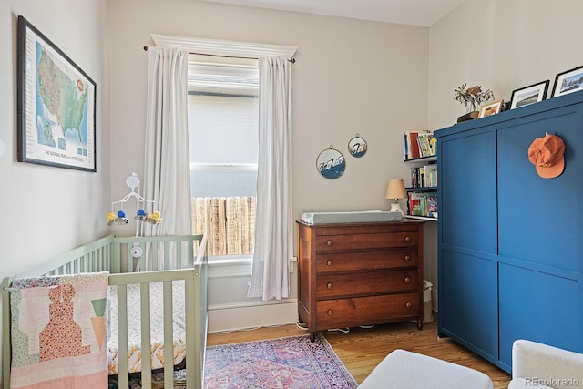 2445 N Franklin St, Denver, CO 80205 - bedroom with wood finished floors and a crib