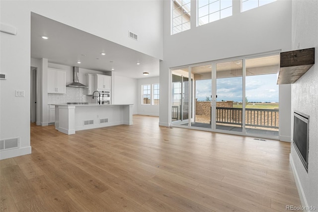 unfurnished living room with sink and light hardwood / wood-style flooring