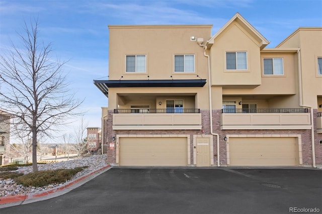 view of property featuring stucco siding, driveway, and a garage