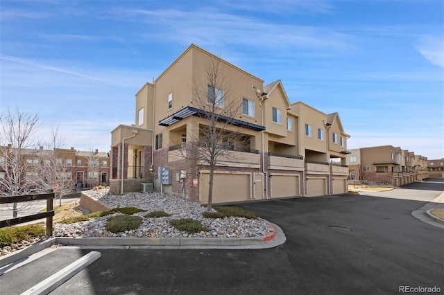 view of building exterior featuring a garage and a residential view