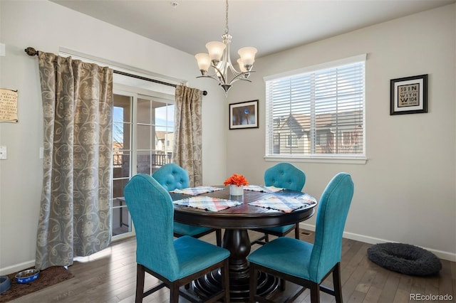 dining room featuring baseboards, a notable chandelier, and hardwood / wood-style floors