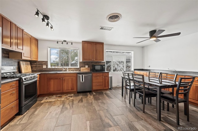 kitchen with decorative backsplash, sink, ceiling fan, and appliances with stainless steel finishes