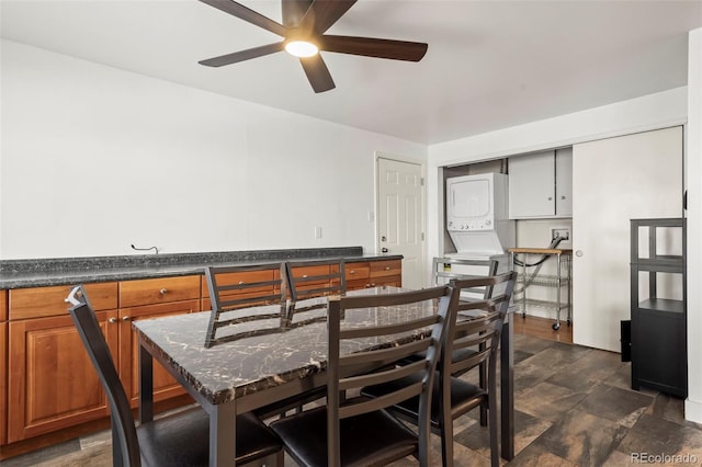 dining room featuring ceiling fan and stacked washer and clothes dryer