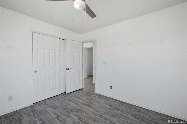 unfurnished bedroom with ceiling fan, dark wood-type flooring, and a closet