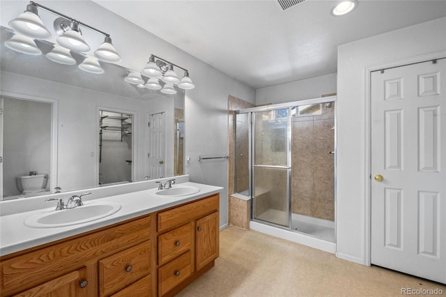 bathroom featuring toilet, an enclosed shower, and vanity