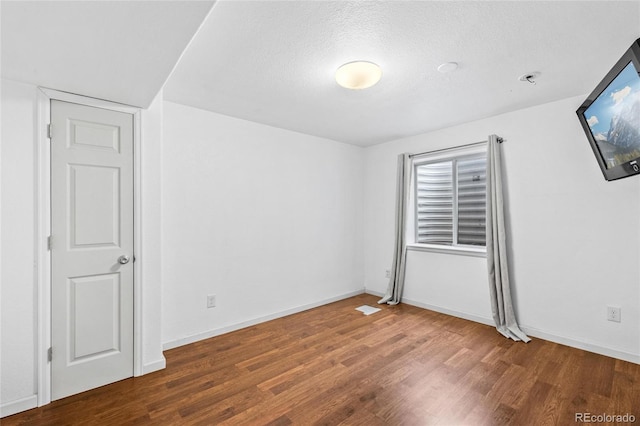 interior space with a textured ceiling and dark wood-type flooring