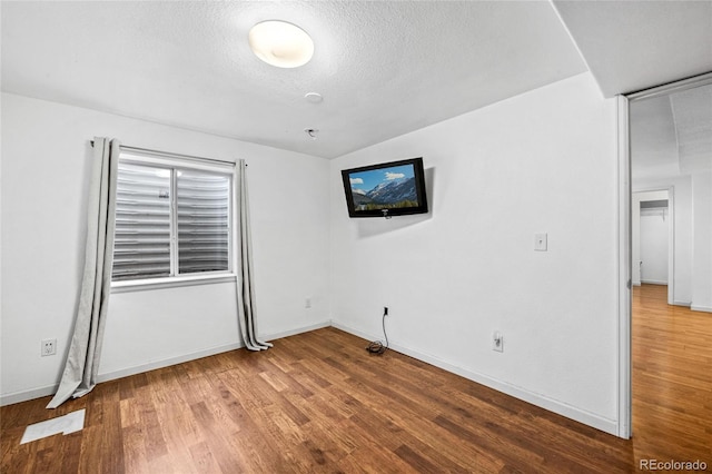 unfurnished room featuring wood-type flooring and a textured ceiling