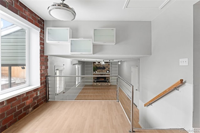 interior space featuring brick wall and wood finished floors