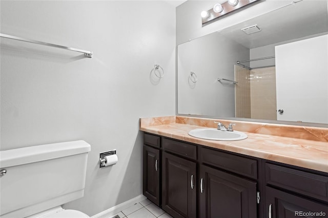 bathroom with toilet, vanity, baseboards, tile patterned floors, and walk in shower