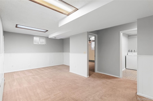 finished basement featuring a ceiling fan, carpet flooring, washer / dryer, and baseboards