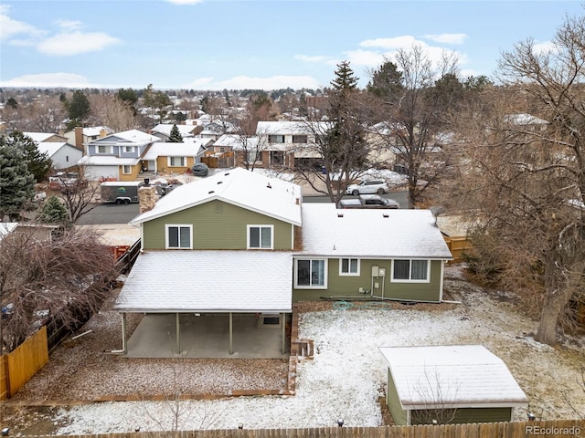 rear view of house featuring a residential view, roof with shingles, and fence