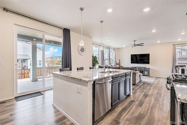 26385 E Canal Pl, Aurora, CO 80018 - kitchen featuring appliances with stainless steel finishes, a sink, wood finished floors, ceiling fan, and light stone counters