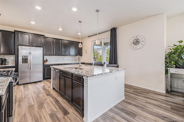 26385 E Canal Pl, Aurora, CO 80018 - kitchen with stainless steel appliances, a sink, light wood-type flooring, decorative backsplash, and recessed lighting