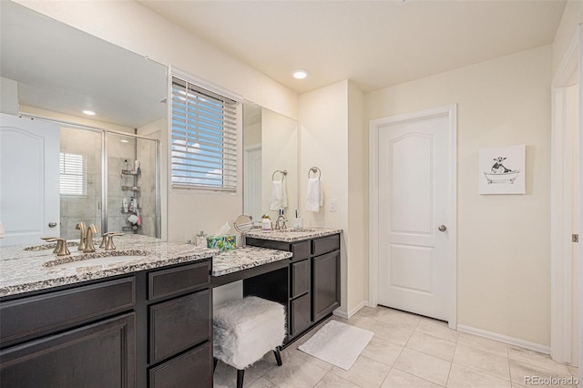 26385 E Canal Pl, Aurora, CO 80018 - full bath featuring a stall shower, tile patterned floors, baseboards, and two vanities