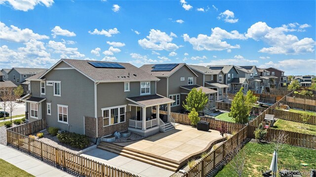 26385 E Canal Pl, Aurora, CO 80018 - back of property featuring a residential view, solar panels, a fenced backyard, and a patio