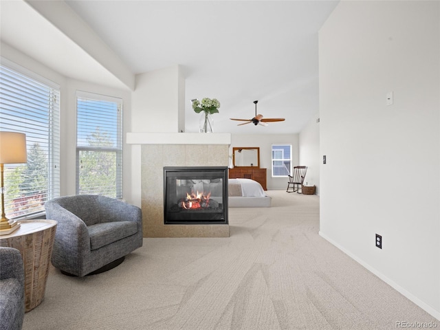 sitting room featuring carpet, a fireplace, ceiling fan, baseboards, and lofted ceiling