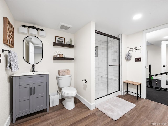 full bath with wood finished floors, a shower stall, toilet, and baseboards