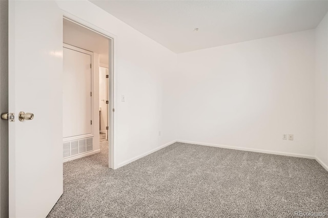 carpeted spare room with baseboards and visible vents