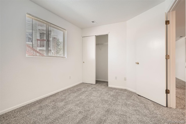 unfurnished bedroom featuring carpet, visible vents, baseboards, and a closet