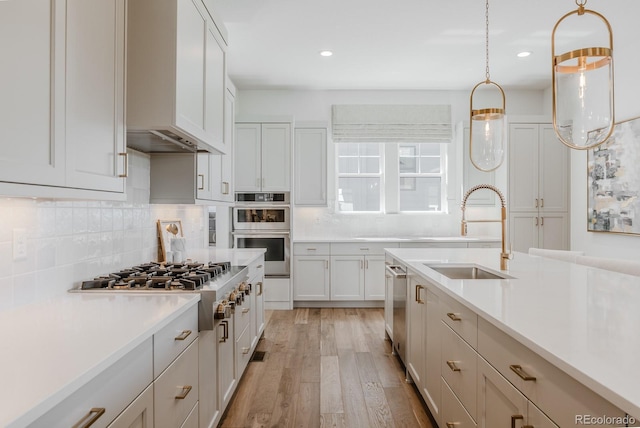 2141 Fountain Cir, Erie, CO 80516 - kitchen featuring stainless steel appliances, a sink, light countertops, tasteful backsplash, and light wood-style floors