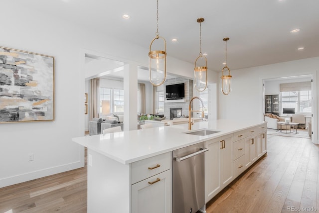 2141 Fountain Cir, Erie, CO 80516 - kitchen featuring open floor plan, a sink, light wood-style floors, light countertops, and stainless steel dishwasher