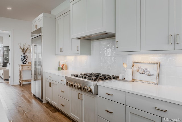 2141 Fountain Cir, Erie, CO 80516 - kitchen with stainless steel appliances, wood finished floors, light countertops, tasteful backsplash, and recessed lighting